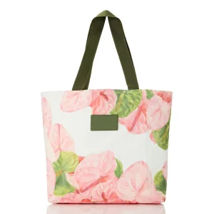 A chic floral tote bag with pink tropical flowers, green leaves, and sturdy green handles, perfect for casual and vacation wear